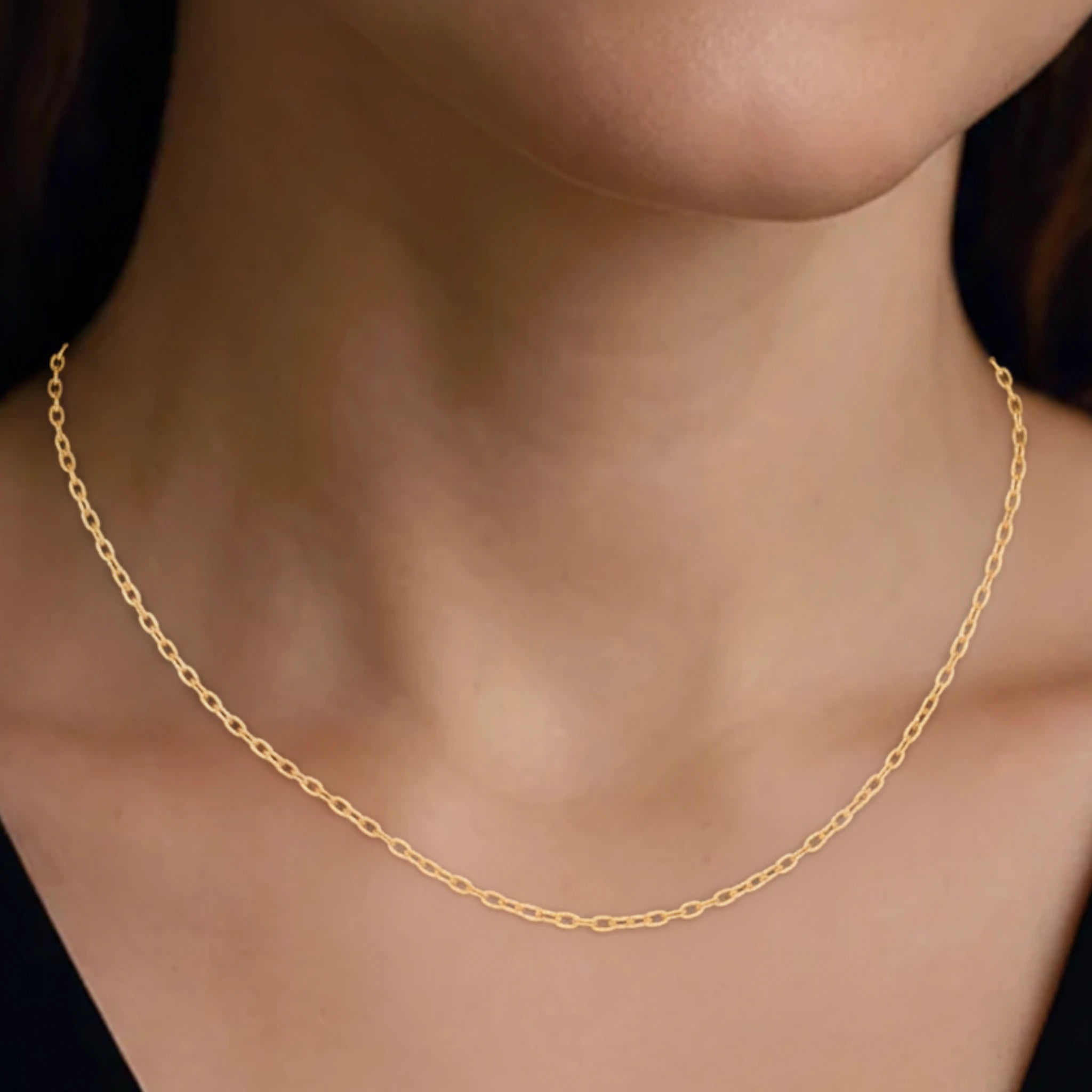 Classic chain medium necklace on a person's neck against a black background