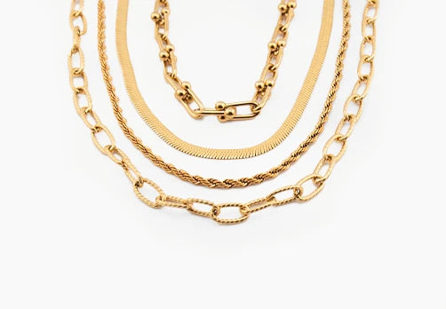 Four gold chains of different styles on a white background