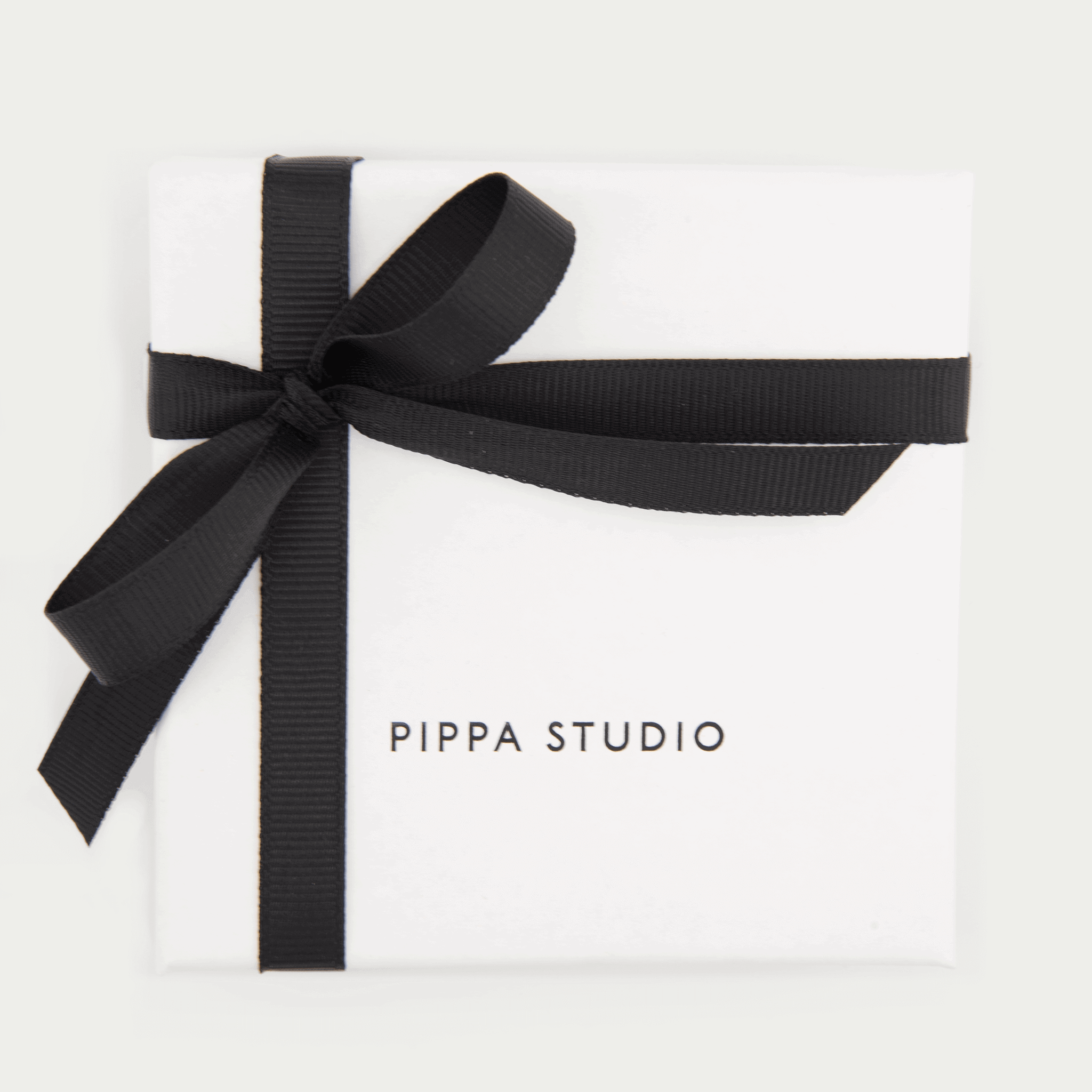 white gift box with black ribbon and pippa studio logo