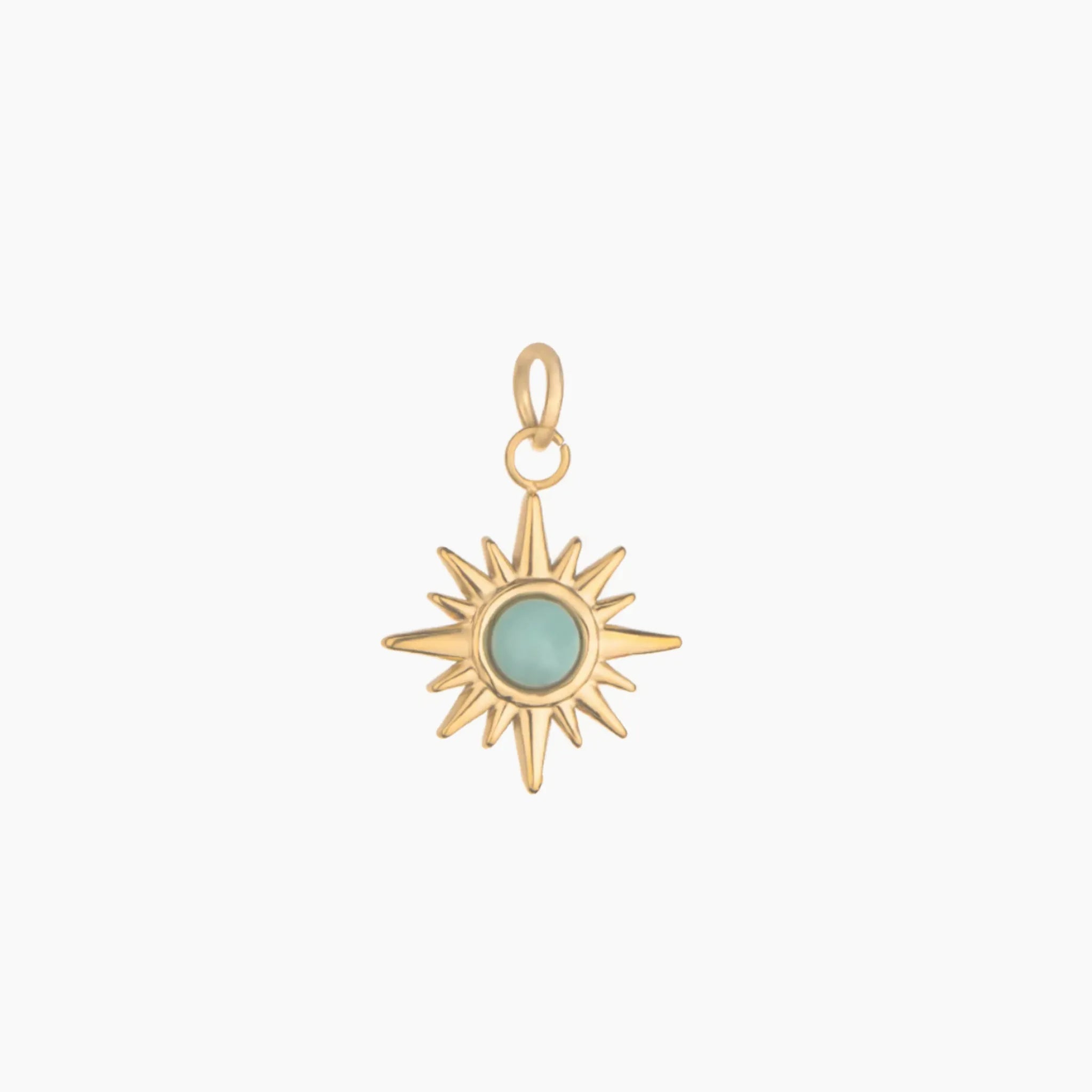 Gold sun-shaped pendant with a green gemstone on a white background