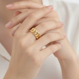 Gold laurel leaf ring on a hand with a soft background