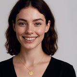 Woman wearing a gold eye pendant necklace