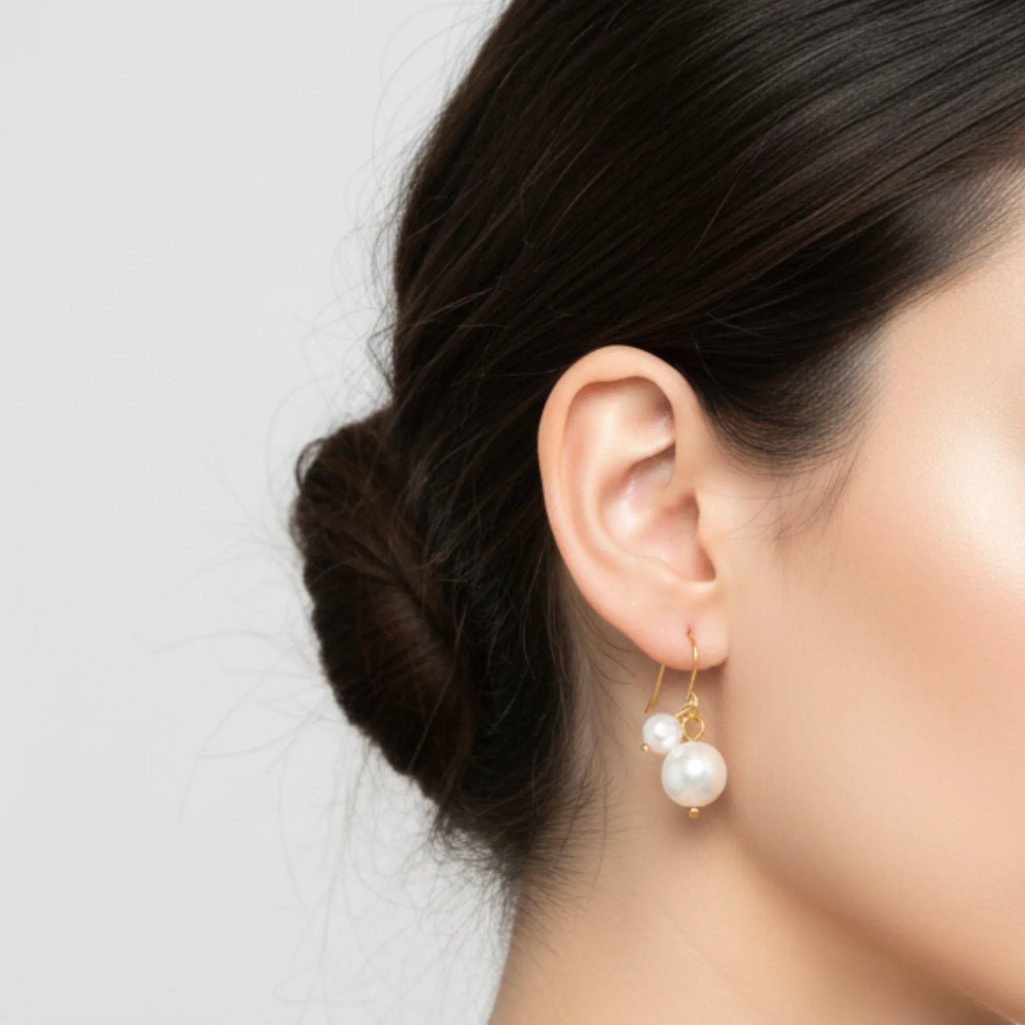 Pearl earring worn by a person with a neutral background
